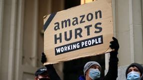 Amazon s&aring;rer det arbejdende folk, st&aring;r der p&aring; et skilt til en protest foran verdens rigeste mand, Amazon-ejeren Jeff Bezos' hjem p&aring; Manhattan i New York. Jeff Bezos kan forvente b&oslash;der i milliardklassen, hvis Amazon udnytter deres markedsstatus. 