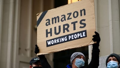 Amazon s&aring;rer det arbejdende folk, st&aring;r der p&aring; et skilt til en protest foran verdens rigeste mand, Amazon-ejeren Jeff Bezos' hjem p&aring; Manhattan i New York. Jeff Bezos kan forvente b&oslash;der i milliardklassen, hvis Amazon udnytter deres markedsstatus. 