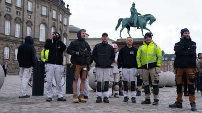 En gruppe t&oslash;mrersvende og h&aring;ndv&aelig;rkere betragter branden i b&oslash;rsbygningen fra Christiansborg Slotsplads.