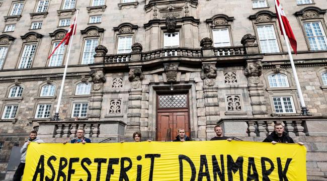 Helga Mathiassen (nummer tre fra venstre) og en gruppe tømrere, der ofte oplever problemer med asbest i deres arbejde, mødte op til samrådet i deres arbejdstøj og med et banner med et klart budskab til politikerne.