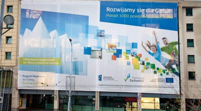 Midt i Stettin, hovedbyen i det nordvestlige Polen, hænger dette kæmpestore banner. ”Over 1.000 grunde til at smile” står der sammen med en lovprisning af EU’s fonde, som regionen får omfattende støtte fra.