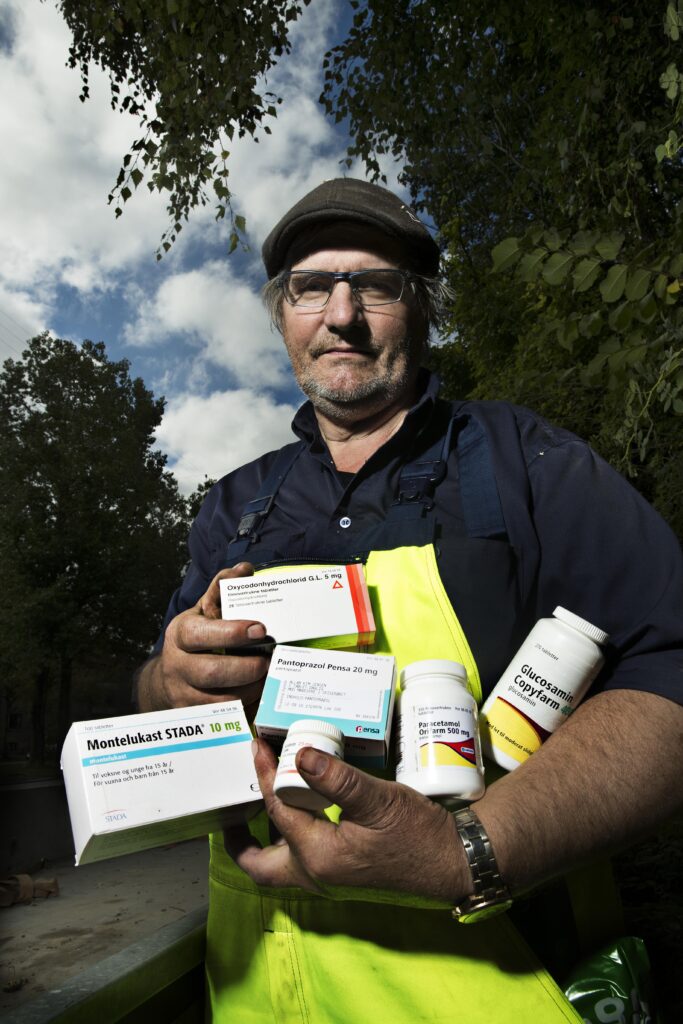 Allan Kim Jensen med favnen fuld af noget af den medicin, som han har taget dagligt i årevis for at kunne passe sit arbejde.
