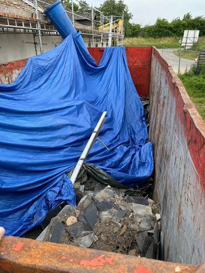 Ifølge naboer til nedrivningen er asbestpladerne blevet knækket af på taget og kylet ind i en sliske ned til en container, der ikke var ordentlig dækket af.